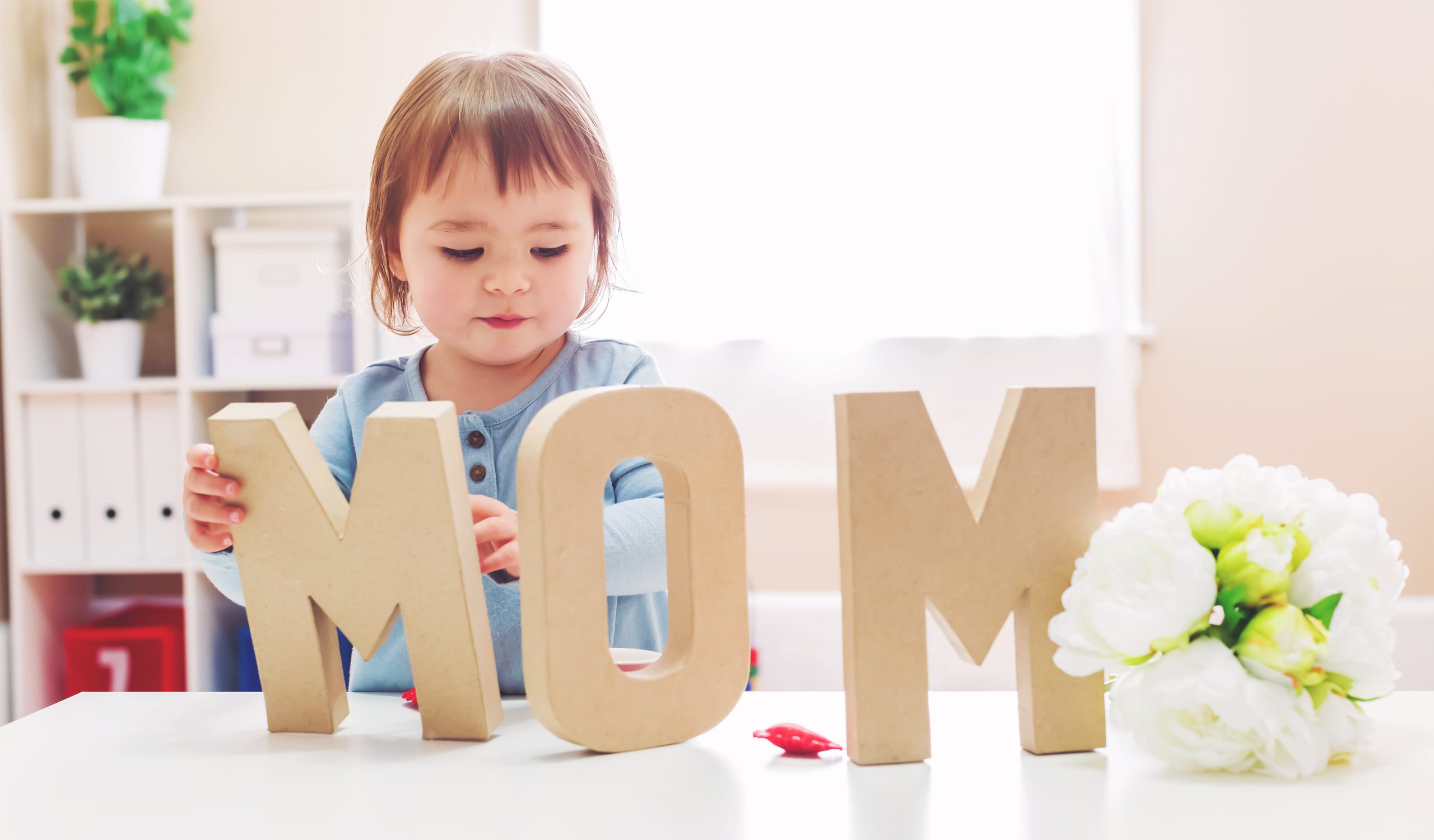 small child with MOM letter cutouts
